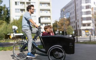 Vater mit Kindern auf Lasten E-Bike